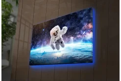 Canvastavla med LED-belysning - Astronaut som svävar i rymden över jorden