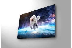 Canvastavla med LED-belysning - Astronaut som svävar i rymden över jorden